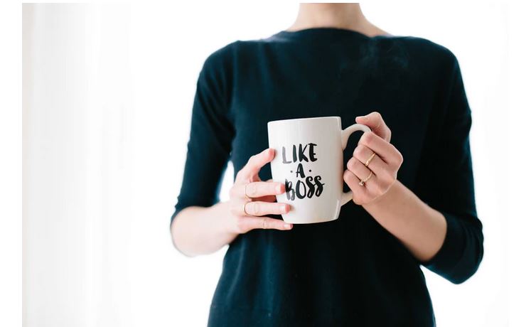 A lady entrepreneur holding a mug labeled' 'Like a boss'